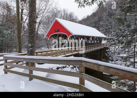 Die Flume Covered Bridge in Franconia Notch, New Hampshire, war an einem Herbstmorgen schneebedeckt. Diese malerische Brücke überquert den Pemigewasset Rive Stockfoto