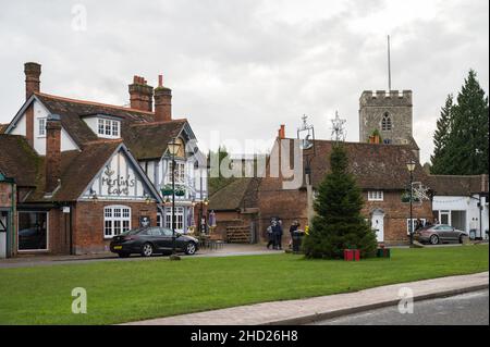 Menschen in Chalfont St. Giles Dorf. Festliche Dekorationen und Weihnachtsbaum auf dem Grün. Buckinghamshire, England, Großbritannien. Stockfoto