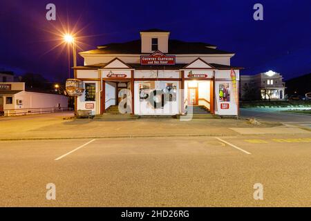 Kleidung und Ski-Shop entlang der Route 112 im Dorf Lincoln, New Hampshire bei Nacht während des Monats Dezember. Stockfoto