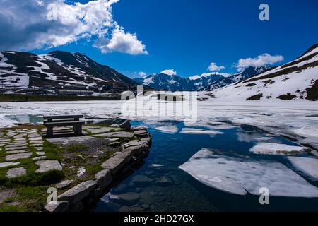 Der Oberalp-See, knapp unterhalb des Oberalppasses auf 2044 m gelegen, ist im Juni noch mit Eis und Schnee bedeckt. Stockfoto