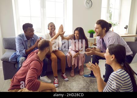 Lächelnde, vielfältige Menschen geben High Five zusammen Stockfoto