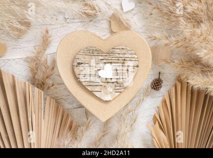Herzförmige Valentines präsentieren in der Nähe von Herzen, getrocknete Palmblätter und Pampass Gras. Frühling rustikal, Cottage chic oder unkonventionelle Konzept Stockfoto
