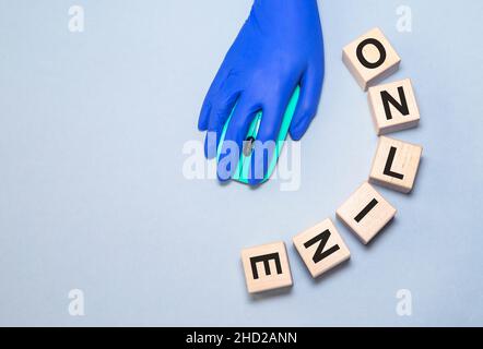 Online-Wort, Quarantäne, zu Hause bleiben Konzept. Hand in medizinischen Handschuh mit Computer-Maus. Globale Auswirkungen von COVID-19. Business Online-Konzept. Person unter Quarantäne gestellt Coronavirus in medizinischen Handschuhen Stockfoto