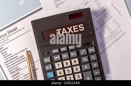 TAXS Wort auf dem Display des Rechners auf Papier Dokumente und goldenen Stift Stockfoto