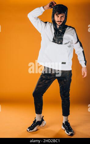 Trendy schöner Mann posiert in modischer Windjacke und schwarzer Hose Stockfoto