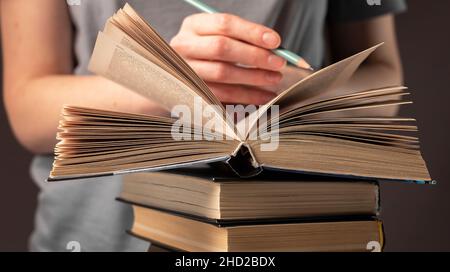 Weibliche Studenten Hände halten Bleistift und Buch lesen, bereiten Sie sich auf die Prüfung am Tisch in der Nacht. Bildungskonzept. Stockfoto