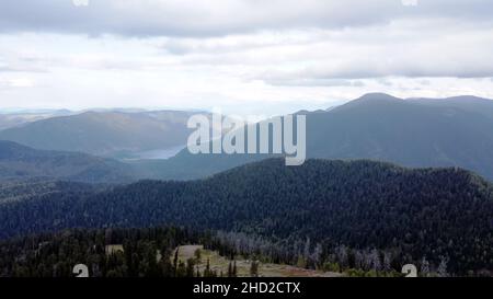 Ein Berg atemberaubende Fluss fließt durch die ruhige Ebene unter den großen Wolken irgendwo in den Bergen, Luftpanorama ohne Menschen Stockfoto