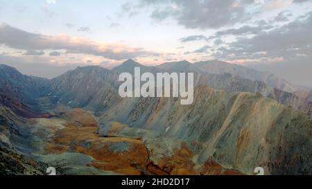 Ein Berg atemberaubende Fluss fließt durch die ruhige Ebene unter den großen Wolken irgendwo in den Bergen, Luftpanorama ohne Menschen Stockfoto