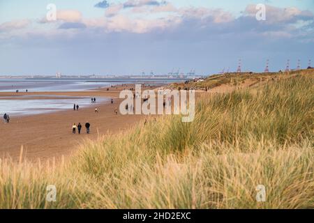 Spaziergänger am Leajowe Beach über den Sanddünen und Dünengras an der Wirral-Küste, aufgenommen am 1. Januar 2022. Stockfoto