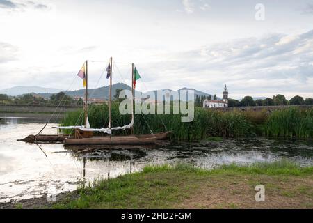 Nachbildung eines historischen Monoxylkanus auf dem Fluss Lima entlang des Camino Portuguese in Ponte de Lima, Portugal. Diese Route des Camino de Santiago p Stockfoto