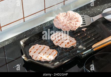 hamburger wird auf einem heißen Grill gekocht Stockfoto