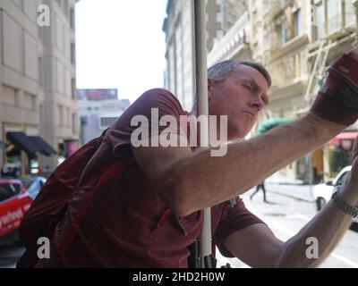 Touristen, die sich aus der Straßenbahn lehnen, machen ein Foto in San Francisco Stockfoto