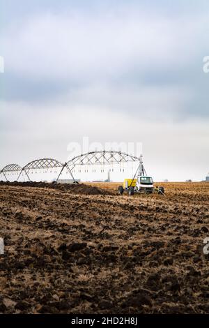 Moderne Bewässerungssysteme auf einem gepflügten Feld im November Stockfoto