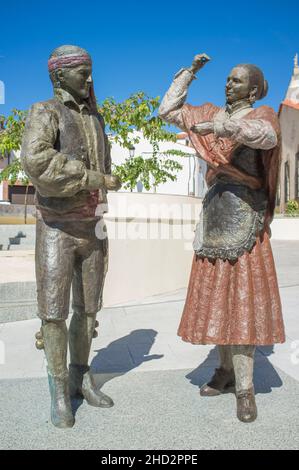 Aceuchal, Spanien - 29th. September 2021: Bronzeskulptur der Piporro Volkstänzer von Gamero Gil. Aceuchal, Badajoz, Extremadura. Weltberühmte Knoblauchstadt Stockfoto