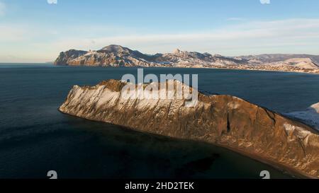 Luftaufnahme am Rande der Bergküste in Grönland. Luftaufnahme auf schneebedeckten Bergen in Grönland. Stockfoto