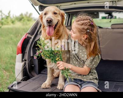 Präteen Mädchen mit goldenen Retriever Hund im Auto Stockfoto