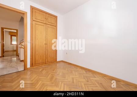 Leeres Zimmer mit Einbauschrank aus Kiefernholz und Eichenparkettböden Stockfoto