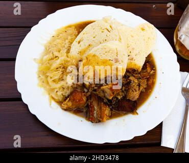 Geschmortes Schweinefleisch und Kohl mit Kartoffelknödeln. Stockfoto