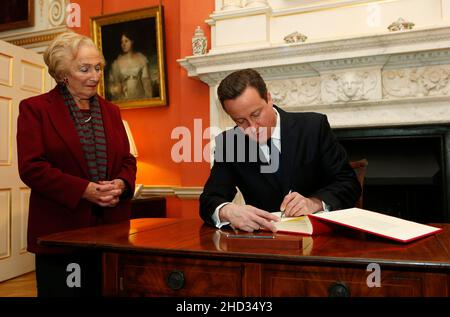 Datei-Foto vom 21/01/2013 des damaligen Premierministers David Cameron, der vor dem Holocaust-Gedenktag das Buch des Engagements unterzeichnete, als die Holocaust-Überlebende Freda Wineman in der Downing Street 10 in London zuschaut. An das „markierbare Leben“ der Holocaust-Überlebenden Freda Wineman wurde nach ihrem Tod im Alter von 98 Jahren erinnert. Ausgabedatum: Sonntag, 2. Januar 2022. Stockfoto