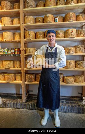 Junger Mann, der Käse bei der Neal s Yard Dairy auf dem Borough Market in Southwark, London, England verkauft. Stockfoto