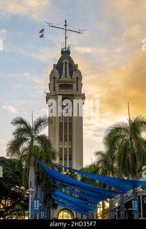 Honolulu, Hawaii - 3. Dezember 2021: Berühmter Aloha Tower am Tor zum Hafen von Honolulu in Honolulu, Hawaii bei Sonnenuntergang Stockfoto