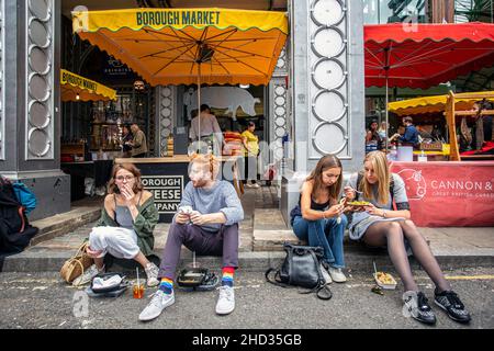 Die Menschen essen gerne Street Food auf dem Borough Market in London Stockfoto