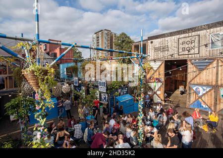 Menschen genießen Sie einen Drink in Brixton Pop, pop-up Container Bars und Restaurants in Brixton, London, UK Stockfoto