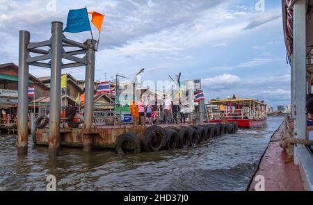 Auf einem Fährboot, das sich dem Abhol- und Abgabepunkt des schwimmenden Docks nähert, mit einer Gruppe von Leuten, die auf das Boot warten. Stockfoto