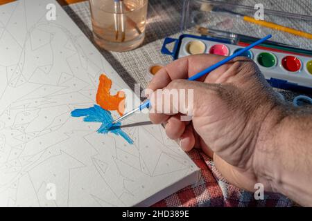 Hände malen mit Aquarellen auf einer Leinwand Stockfoto