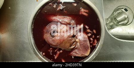 Wildkaninchen mariniert in Rotwein auf einer Küchenspüle Stockfoto