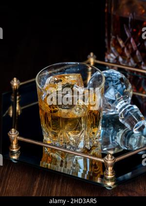 Ein Glas Whiskey auf einem Glastablett vor schwarzem Hintergrund. Stockfoto