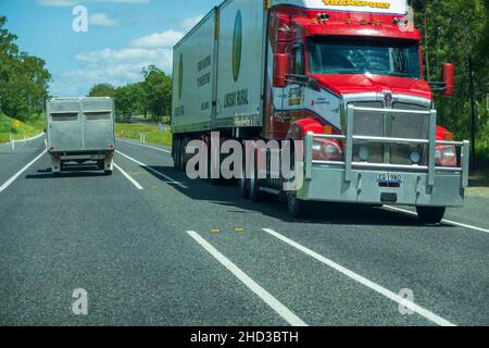 Bruce Highway, Proserpine, Queensland, Australien - Dezember 2021: Sattelschlepper auf dem Highway, vorbei an einem selbstgemachten Wohnwagen Stockfoto