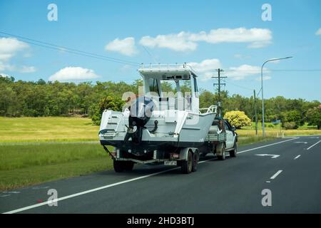 Bruce Highway, Proserpine, Queensland, Australien - Dezember 2021: Ein Motorboot auf Anhänger, das von einem kleinen Lastwagen auf einer Landstraße geparkt wird Stockfoto