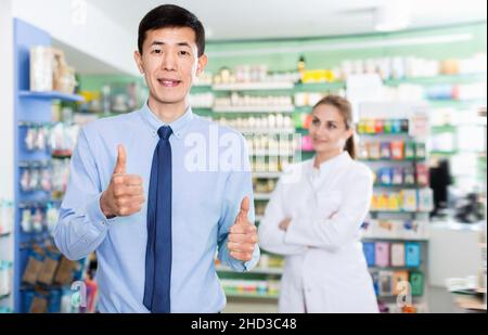 Porträt eines lächelnden koreanischen Mannes Client in der Apotheke. Stockfoto