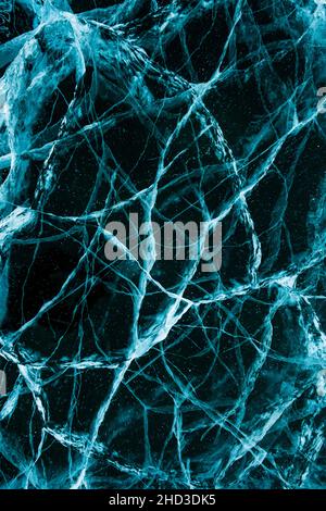 Textur von schönem blauem Eis mit Rissen im gefrorenen See. Winter Natur Hintergrund. Vertikales Foto. Stockfoto