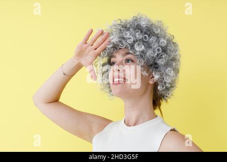 Fröhliche junge Frau in Perücke, die im Studio steht Stockfoto