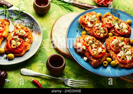 Dünne Schicht Fleisch, paniert in Paniermehl mit Käse, Oliven und Tomaten. Fleischgericht - Schnitzel Stockfoto