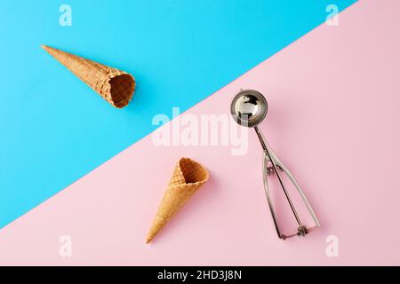 Eiszapfen mit Schaufel auf pastellrosa und blauem Hintergrund. Minimales sommerliches Essenskonzept. Flach liegend. Stockfoto