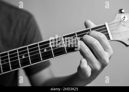 Männer fangen Akkorde lernen Gitarre zu spielen. Closeup-Musiker fangen Gitarrenakkorde. Männliche Musiker halten Akkorde und Strum Gitarre. Stockfoto