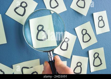 Gezeichnete Figur und Hand mit Vergrößerungsglas. Konzept der Mitarbeitererkennung. Stockfoto