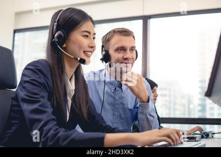 Assistent, der das Call Center-Personal im Büro überwacht. Assistenzmitarbeiter in einem Callcenter. Executive Trainer für den Kundenservice, der von unterstützt wird Stockfoto
