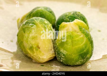 Mehrere gefrorene Bio-Rosenkohl in einer Keramikschale, Nahaufnahme. Stockfoto