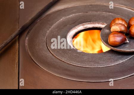 Nahaufnahme einiger Kastanien am Feuer eines Holzofens.das Foto zeigt etwas typisches aus der Herbstsaison und ist im horizontalen Format aufgenommen. Stockfoto