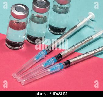 Medizinische Geräte, einschließlich Spritzen mit hypodermischen Nadeln mit Sicherheitsverschlüssen und Fläschchen mit einer klaren Flüssigkeit. Stockfoto