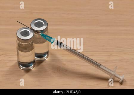Medizinische Geräte, einschließlich Spritze mit hypodermischer Nadel und Fläschchen mit einer klaren Flüssigkeit. Stockfoto