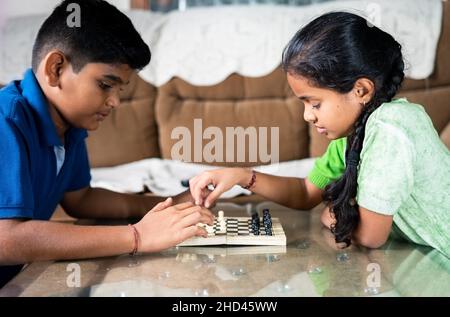 Konzentrieren Sie sich auf Mädchen, konzentrierte Geschwister Kinder beschäftigt spielen Schach zu Hause - Konzept der Kindheit geistige Entwicklung, Gameplay und Unterhaltung Stockfoto
