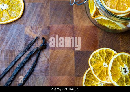 Dehydrierte Orangen, Vanillebohnen, Macadamianüsse auf dem Tisch Stockfoto