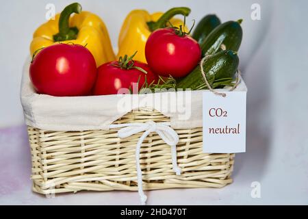 Korbkorb mit klimaneutralem Produktlabel auf frischem Gemüse. CO2-Kennzeichnung. Netto kohlenstofffrei, emissionsfrei. Bio-Landwirtschaftsprodukte aus Loca Stockfoto