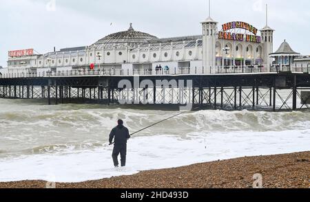 Brighton UK 3rd January 2022 - Ein Fischer treibt an einem rauen Tag am Brighton Palace Pier während des windigen Wetters am Neujahrsfeiertag in England aus : Credit Simon Dack / Alamy Live News Stockfoto