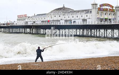 Brighton UK 3rd January 2022 - Ein Fischer treibt an einem rauen Tag am Brighton Palace Pier während des windigen Wetters am Neujahrsfeiertag in England aus : Credit Simon Dack / Alamy Live News Stockfoto